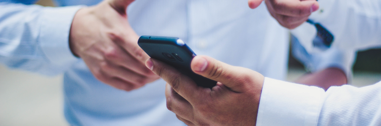 Dos compañeros revisando el servicio de ciberseguridad Euskaltel en su móvil
